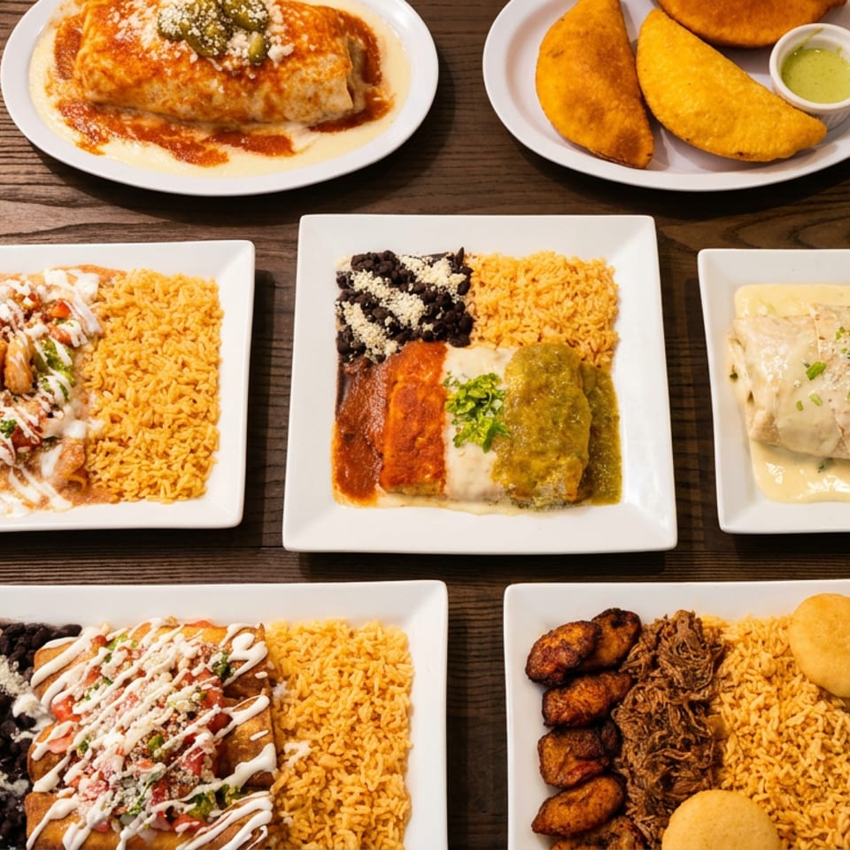 Assorted Mexican dishes arranged on white plates, including enchiladas, burritos, empanadas, rice, beans, plantains, and sauces on a wooden table.